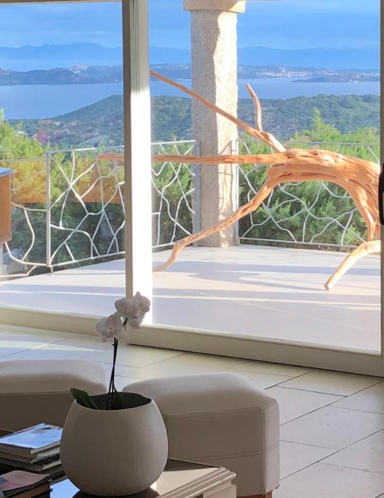 un vase avec une fleur sur une table devant une fenêtre dans l'établissement Smeralda Oasis, à Arzachena 18 autres photos