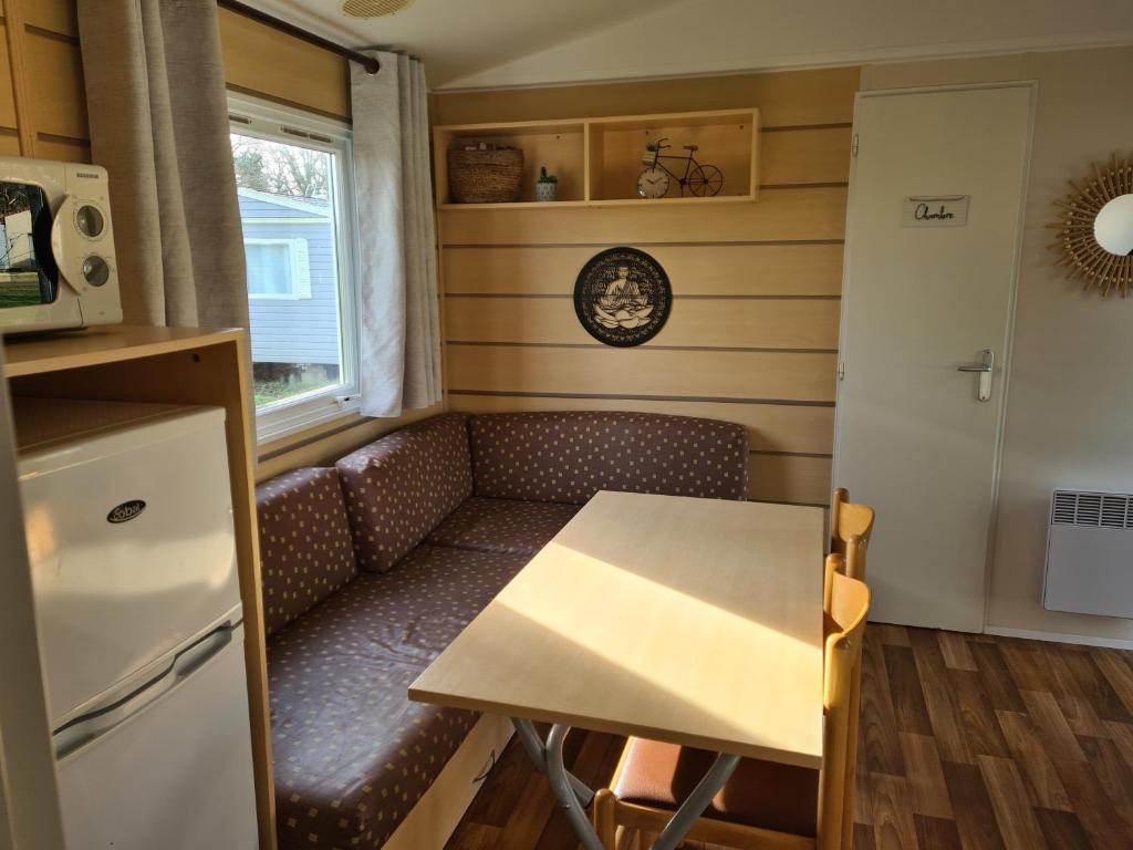 une petite cuisine avec une table et un canapé dans l'établissement Mobil-home 5 places, à La Boissière-de-Montaigu