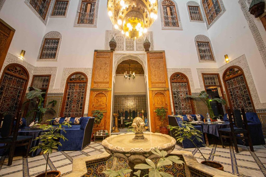 Cette grande chambre comprend une table et un lustre. dans l'établissement Riad Fes Iline, à Fès