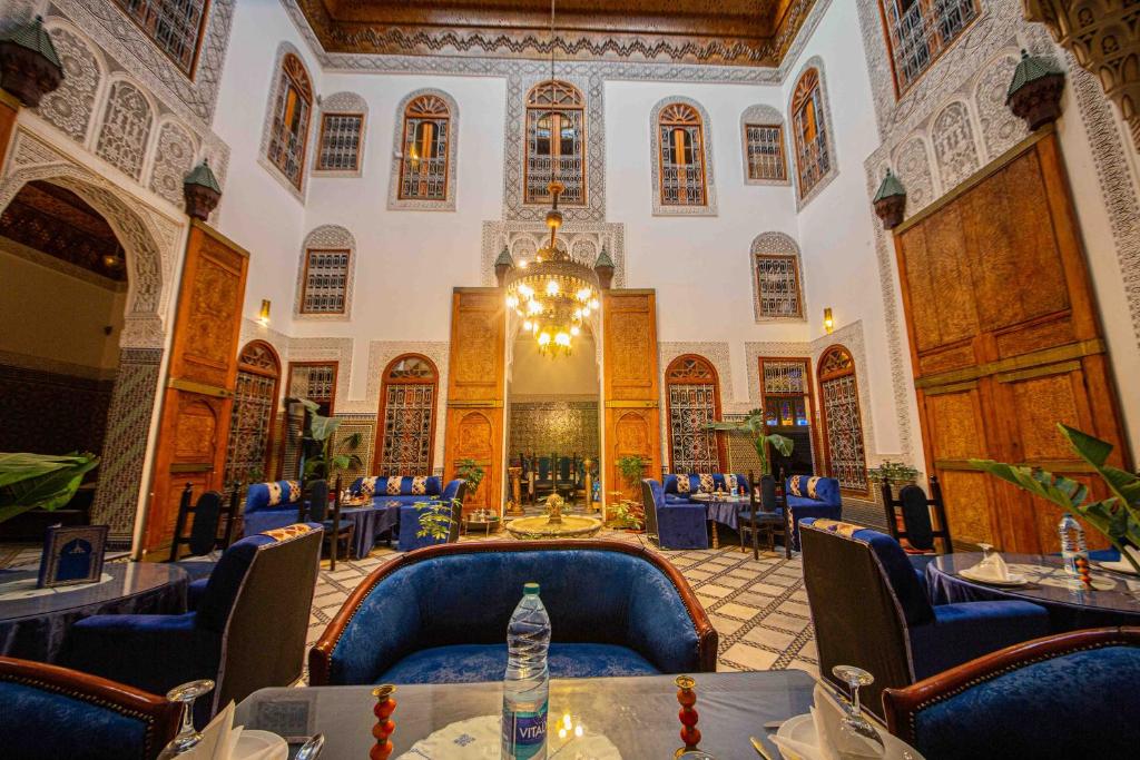 un restaurant avec des chaises et des tables bleues dans un bâtiment dans l'établissement Riad Fes Iline, à Fès