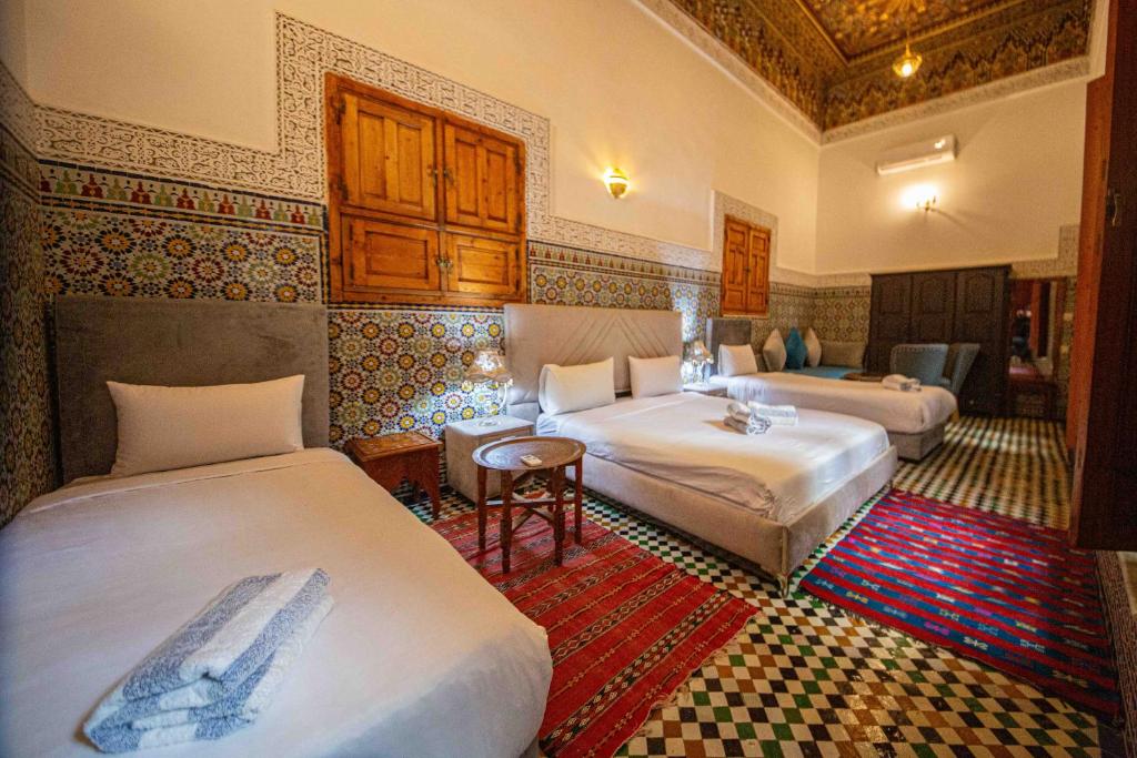 une chambre d'hôtel avec deux lits et une table dans l'établissement Riad Fes Iline, à Fès 37 autres photos