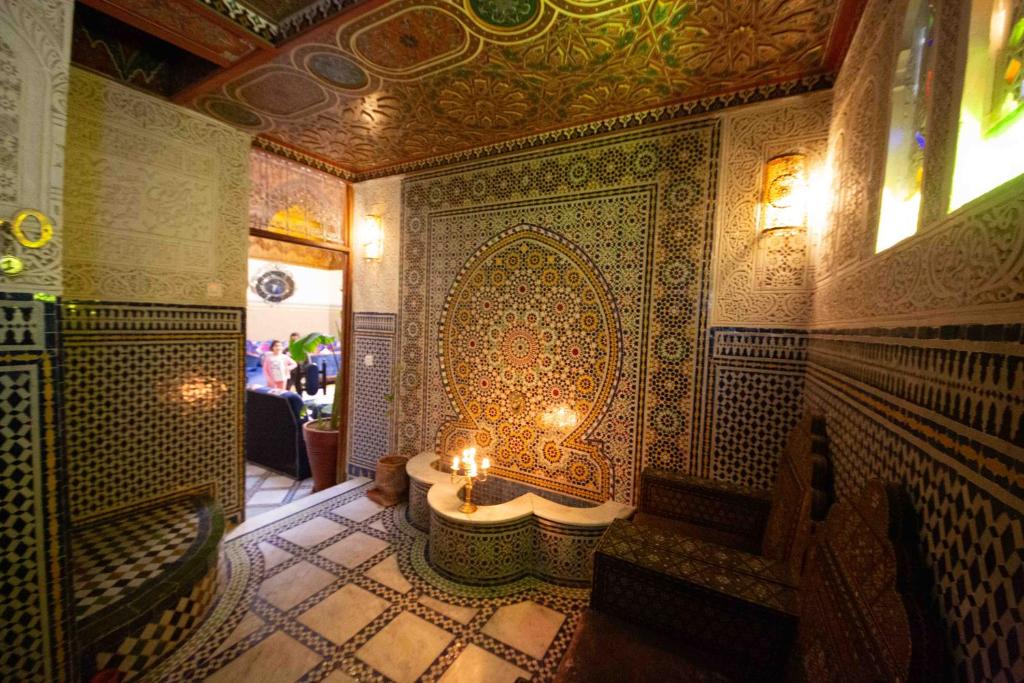 Cette chambre dispose d'une table avec des bougies sur le mur. dans l'établissement Riad Fes Iline, à Fès