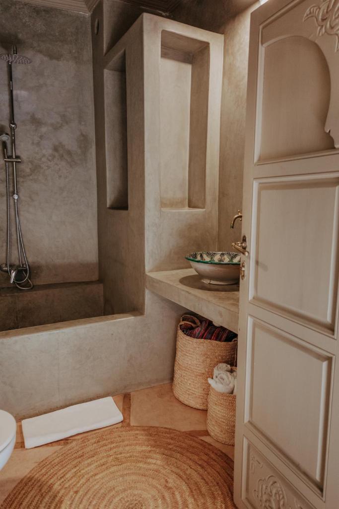 La salle de bains est pourvue d'une douche, de toilettes et d'une porte. dans l'établissement Riad 117, à Marrakech 37 autres photos