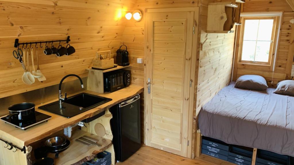- une cuisine avec évier et un lit dans une chambre dans l'établissement Camping Les Hauts de Rosans, à Rosans