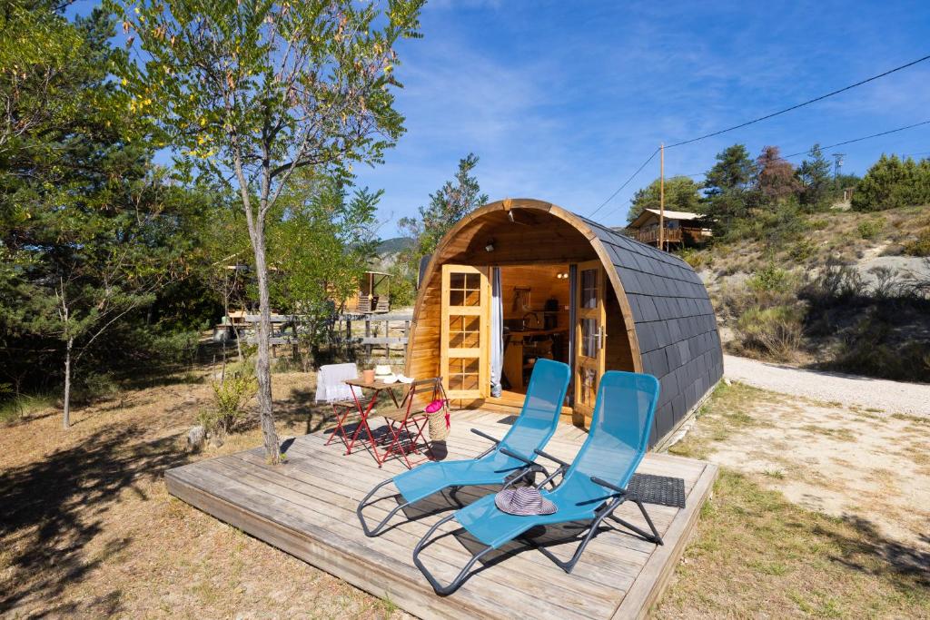 - deux chaises assises sur une terrasse devant une petite maison dans l'établissement Camping Les Hauts de Rosans, à Rosans
