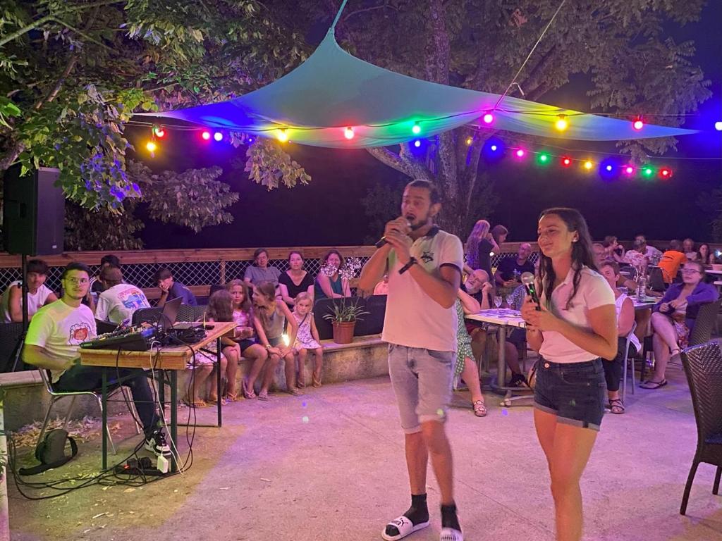 Un homme et une femme debout sur une scène avec des microphones dans l'établissement Camping Les Hauts de Rosans, à Rosans