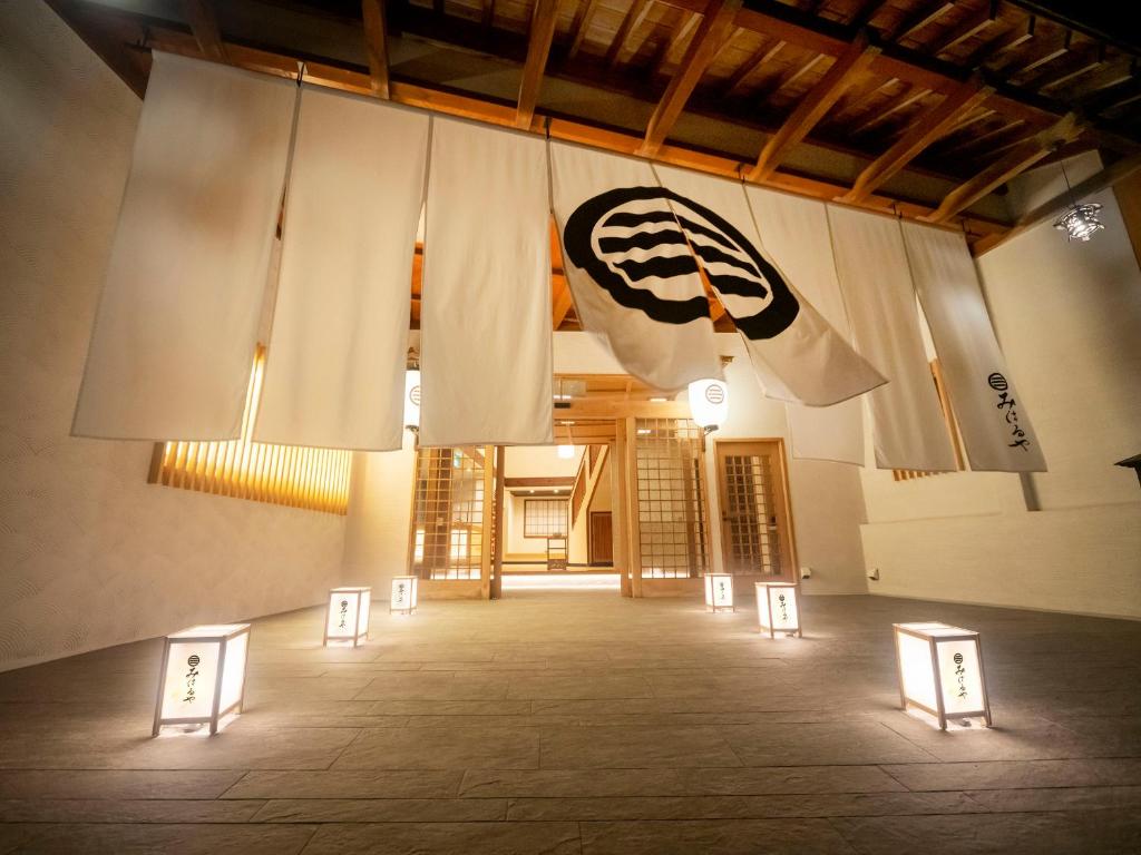 une chambre avec des tables et un drapeau sur le côté d'un bâtiment dans l'établissement Izu Atagawa Onsen Miharuya, à Higashiizu