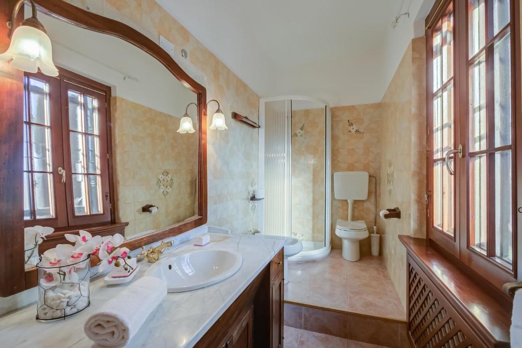 une salle de bain avec un lavabo, des toilettes et un miroir dans l'établissement Villa Oasi With Private Pool - Happy Rentals, à Sirmione 45 autres photos