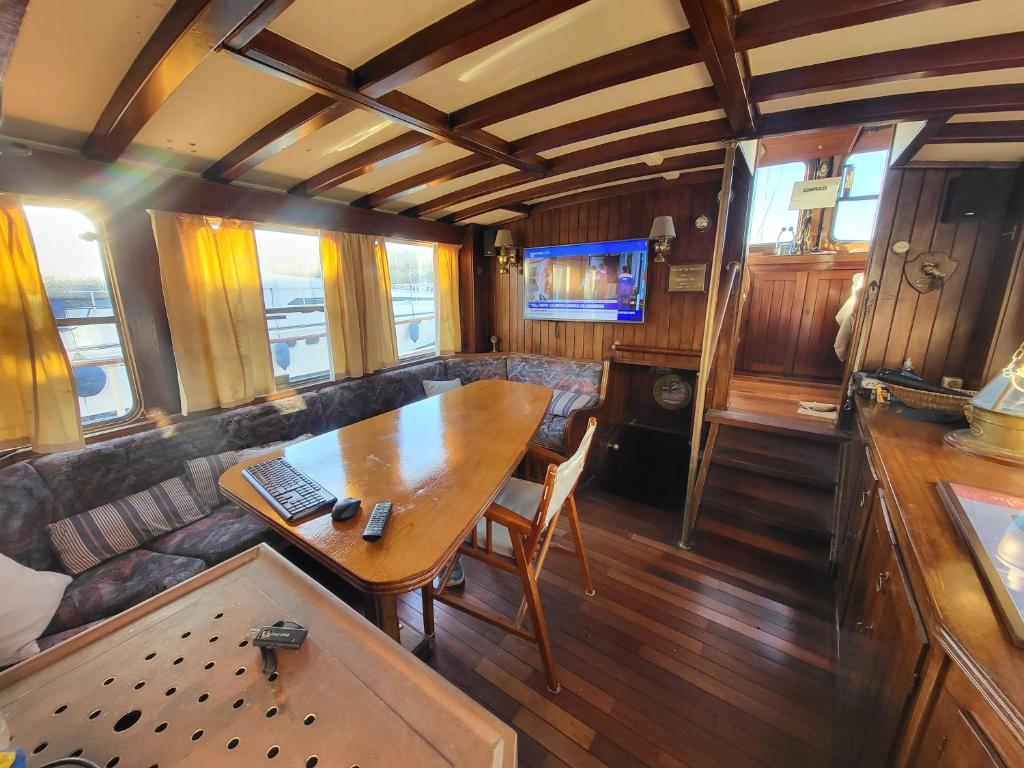 - un salon avec une table dans un wagon dans l'établissement Bateau pirate, à Crespinet