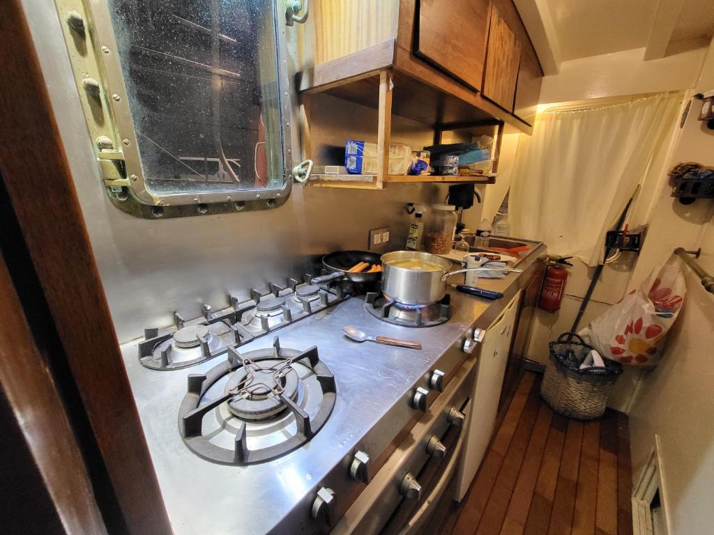 Il comprend une petite cuisine équipée d'un four avec plaques de cuisson. dans l'établissement Bateau pirate, à Crespinet