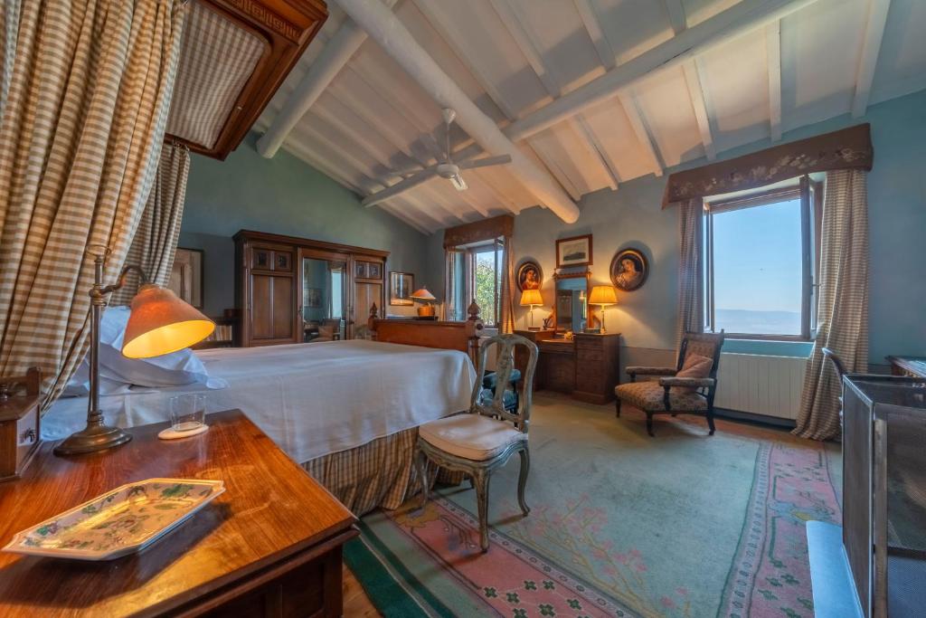 une chambre avec un lit, un bureau et des chaises dans l'établissement Podere Manafiore, à Monticchiello