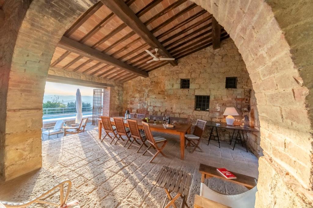 une voûte dans une chambre avec une table et des chaises dans l'établissement Podere Manafiore, à Monticchiello