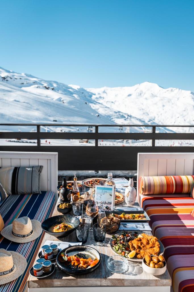 une table avec des assiettes de nourriture au sommet d'une montagne dans l'établissement Fahrenheit Seven Val Thorens, à Val Thorens