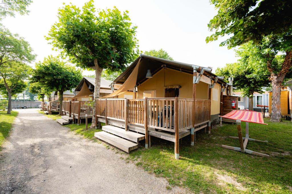 une maison avec une terrasse couverte et des escaliers. dans l'établissement Glamping Bretagne, à Quimper