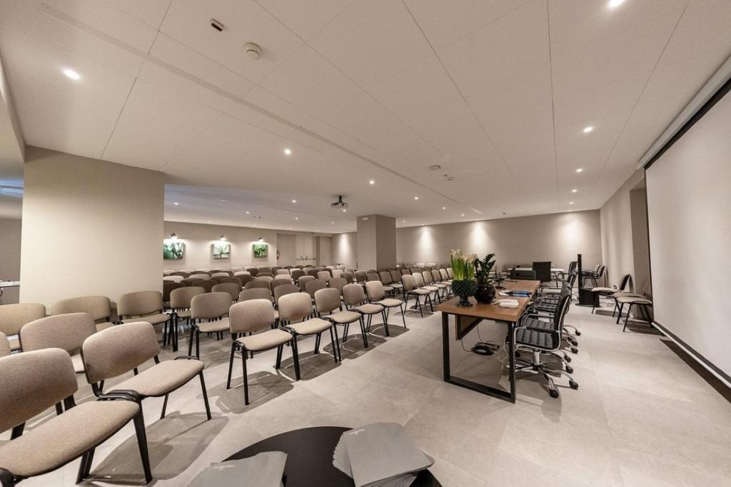 une salle de conférence avec des chaises, des tables et un écran dans l'établissement Mangia's Himera Resort, à Campofelice di Roccella 19 autres photos
