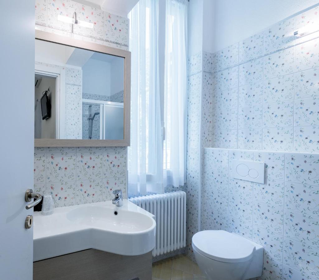 une salle de bain blanche avec un lavabo et des toilettes dans l'établissement Villa Belvedere Como Lake Relais, à Argegno