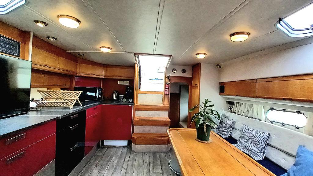 une cuisine avec une table en bois au milieu dans l'établissement Eden marine, à Montalieu-Vercieu