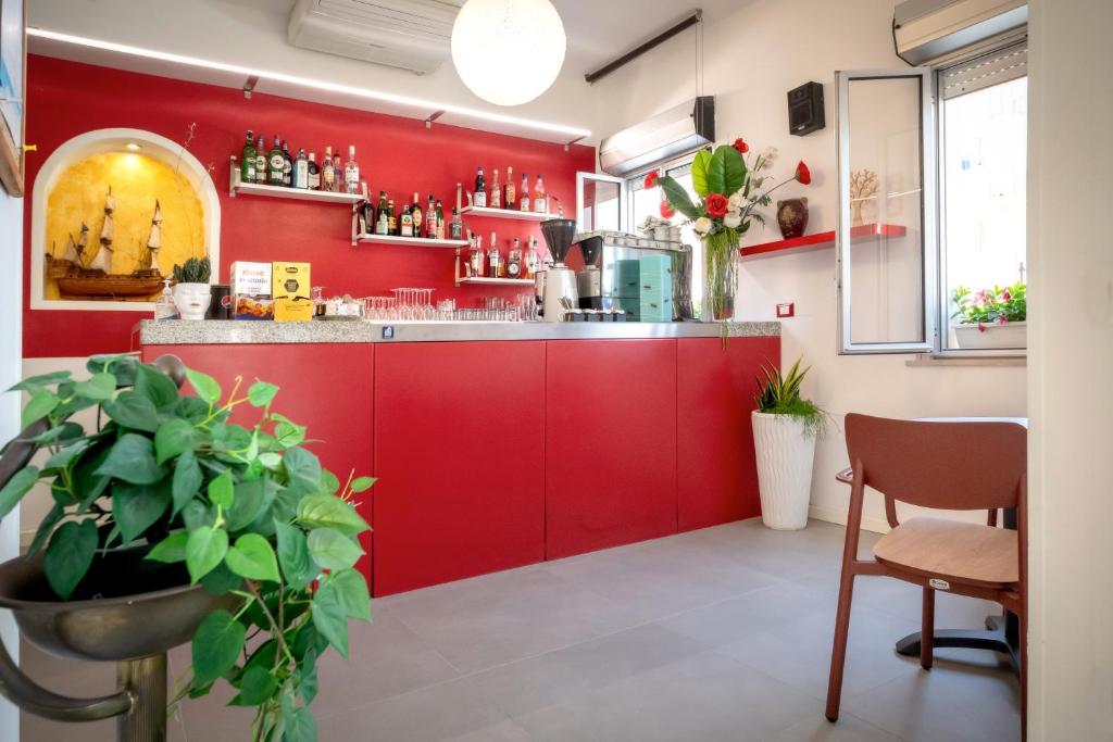 une cuisine rouge avec un mur rouge dans l'établissement Hotel Firenze, à Caorle 22 autres photos