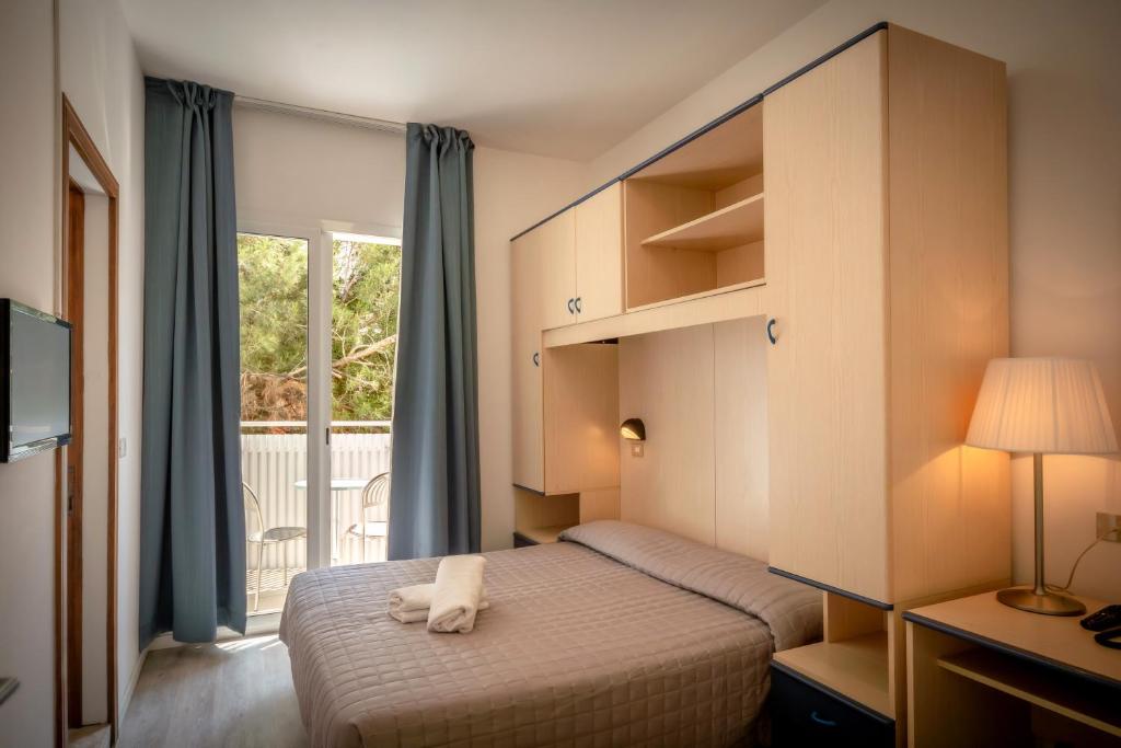 une chambre d'hôtel avec un lit et une fenêtre dans l'établissement Hotel Firenze, à Caorle