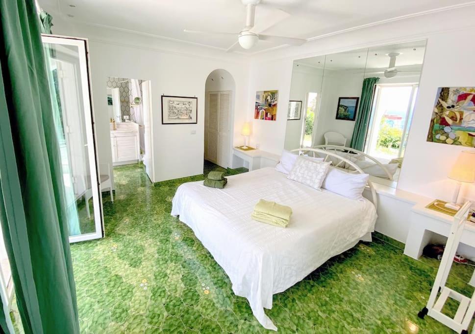 une chambre avec un lit blanc et un miroir dans l'établissement Maison Il Vervece - Sorrento, à Massa Lubrense