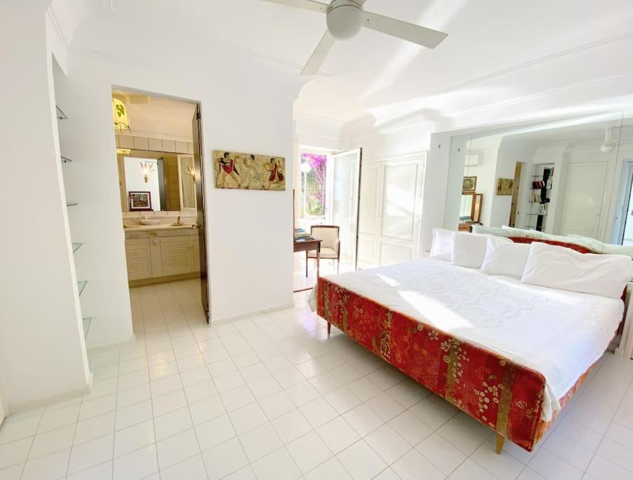 - une chambre blanche avec un grand lit et une cuisine dans l'établissement Maison Il Vervece - Sorrento, à Massa Lubrense