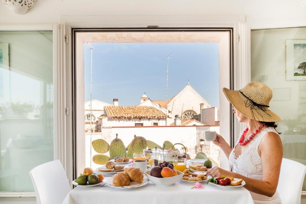 une femme assise à une table avec une assiette de nourriture dans l'établissement Hotel Corte Altavilla, à Conversano