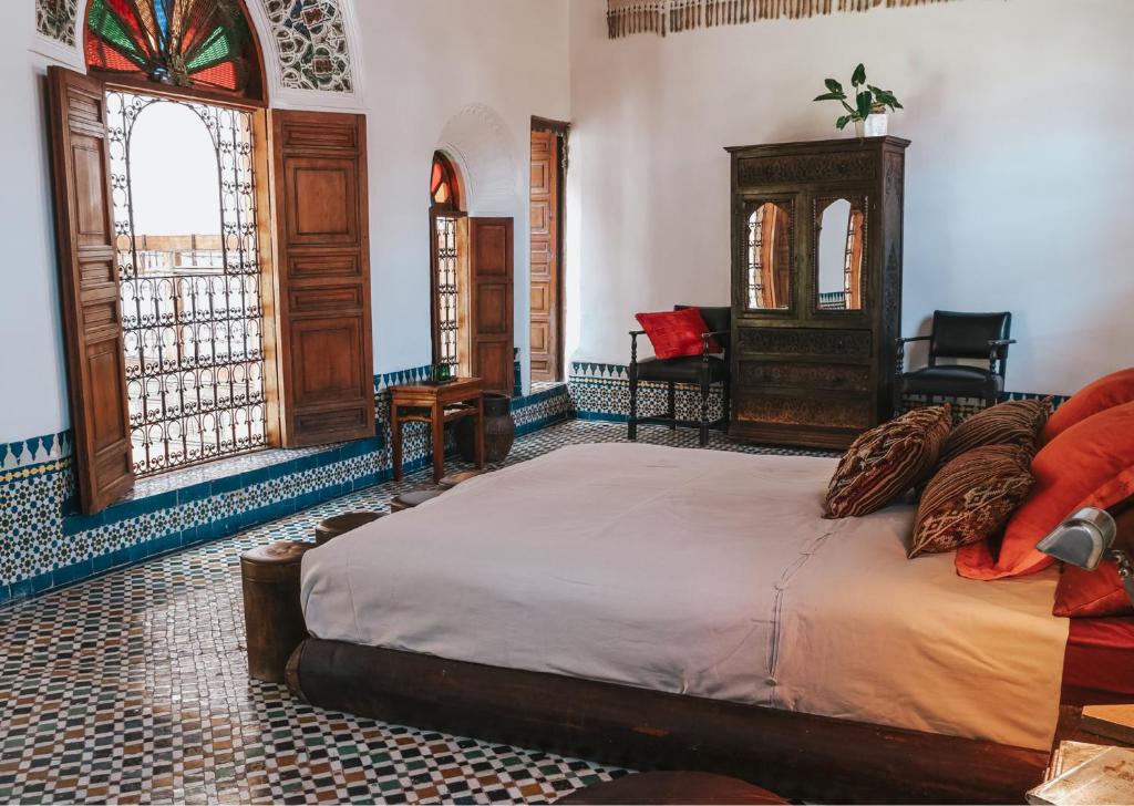 une chambre avec un lit, une chaise et une fenêtre dans l'établissement Riad 9 Fez, à Fès