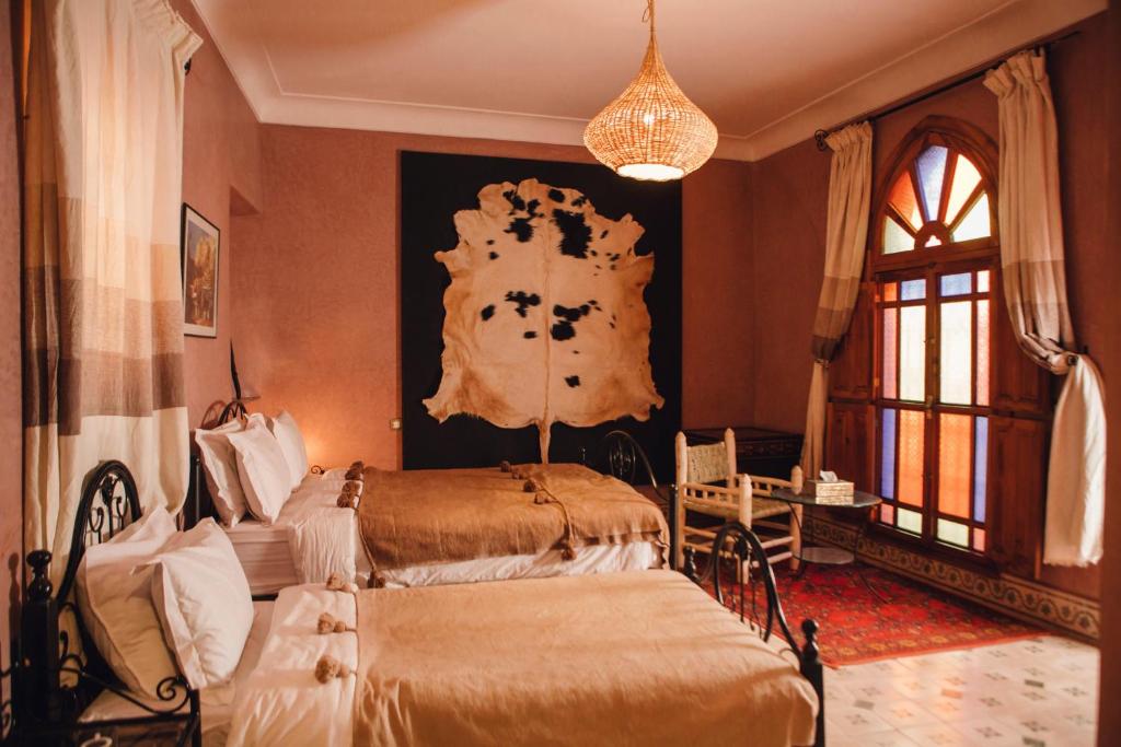 une chambre avec deux lits et un tableau au mur dans l'établissement Riad Bensaid, à Marrakech