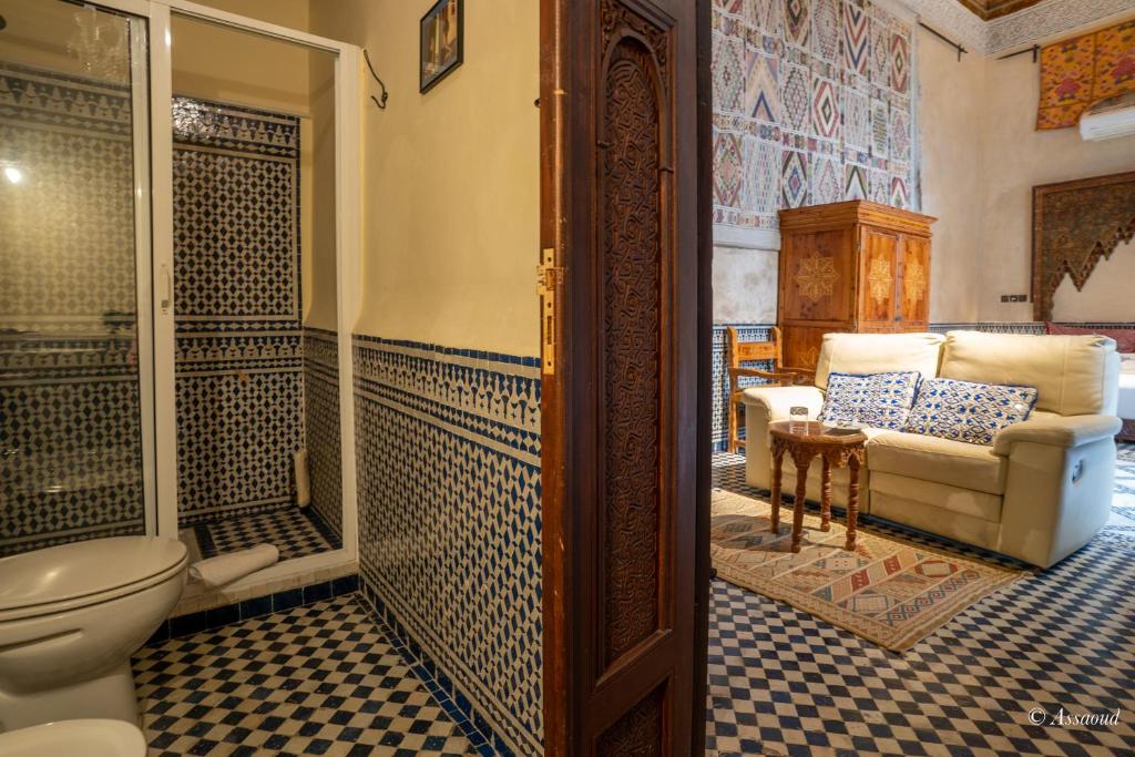 La salle de bains est pourvue de toilettes et d'un canapé. dans l'établissement Riad Fes Palacete, à Fès