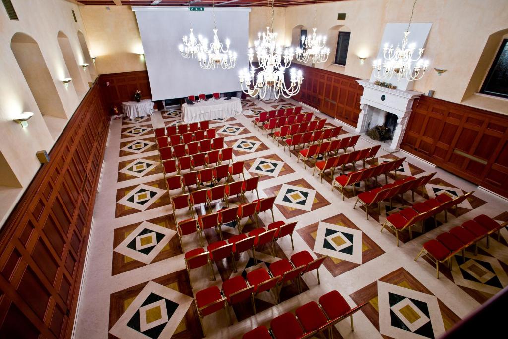 - une salle de banquet avec des chaises rouges dans l'établissement Hotel Relais dei Normanni, à Monte SantʼAngelo