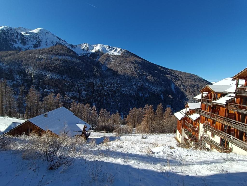 un bâtiment dans la neige avec une montagne en arrière-plan dans l'établissement Montagne Les Orres, aux Orres