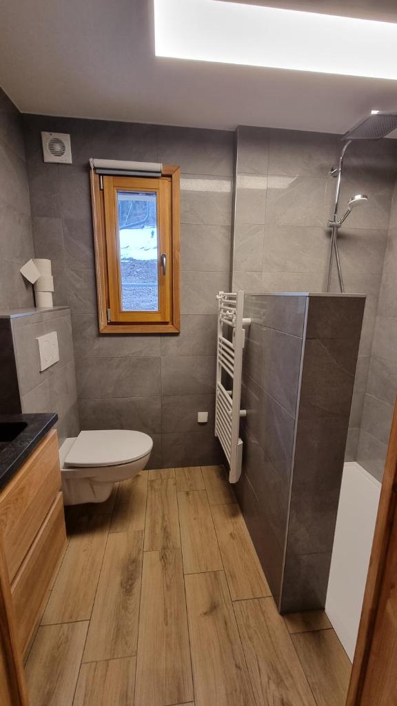 une salle de bain avec toilettes et fenêtre dans l'établissement L'Étoile du Linga, à Châtel