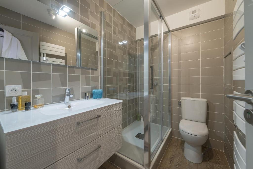 une salle de bain avec toilettes, lavabo et douche dans l'établissement Les Chalets Du Jardin Alpin, à Val dʼIsère 21 autres photos