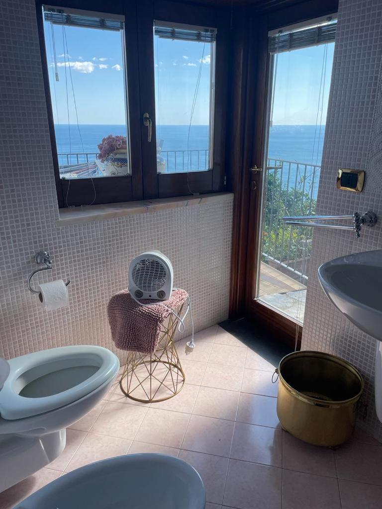 La salle de bains est pourvue de 2 toilettes, d'un lavabo et d'une fenêtre. dans l'établissement Villa Stone - De Vivo Realty Positano, à Positano
