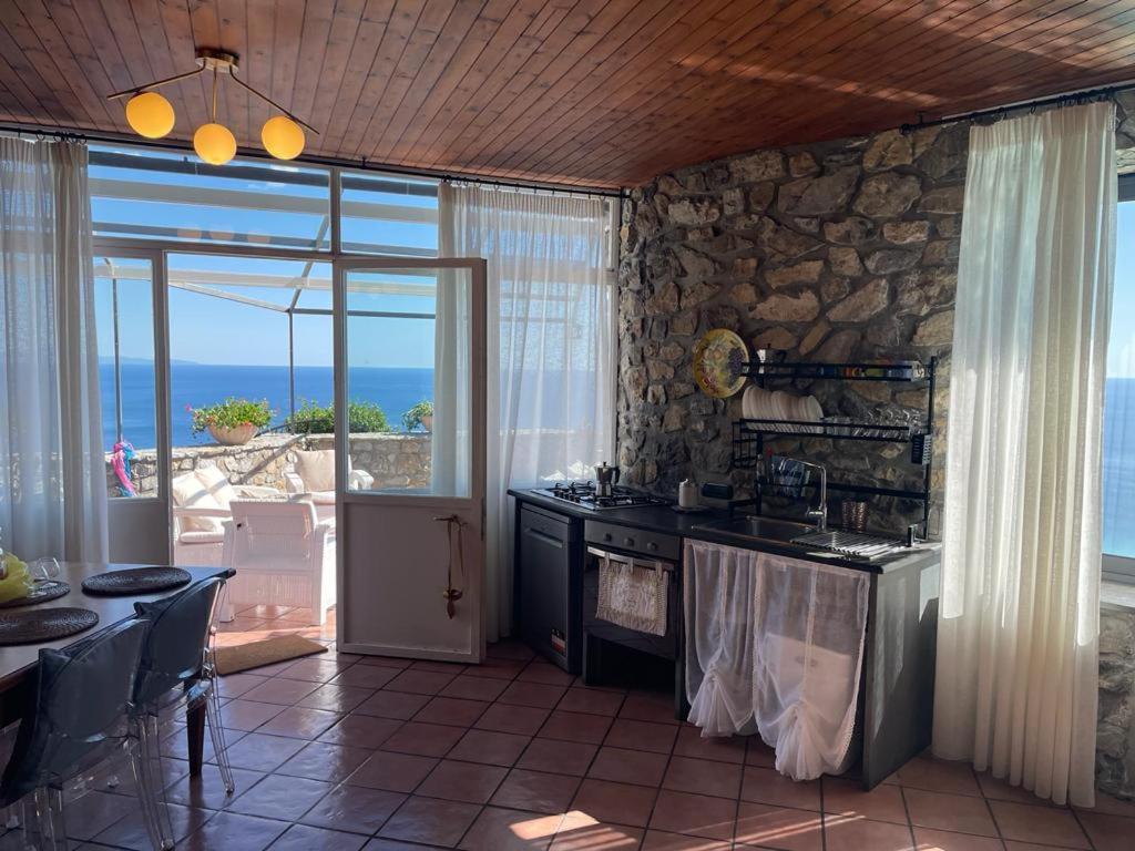 Il comprend une cuisine avec une cuisinière et un mur en pierre. dans l'établissement Villa Stone - De Vivo Realty Positano, à Positano