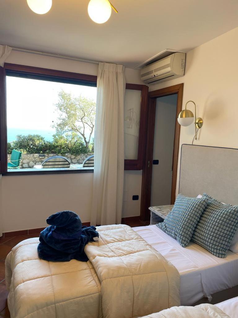 une chambre avec un lit et une grande fenêtre dans l'établissement Seacliff Heaven - De Vivo Realty Positano, à Arola
