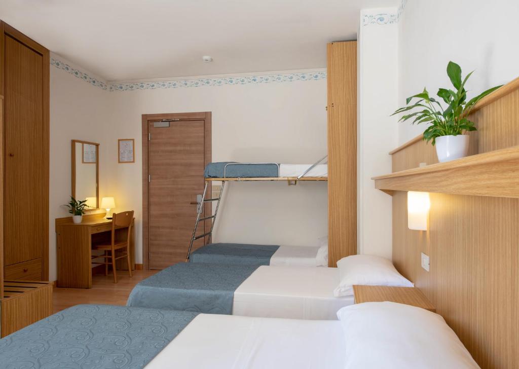 une chambre avec deux lits superposés et un bureau dans l'établissement Hotel Laurin, à Lido di Jesolo