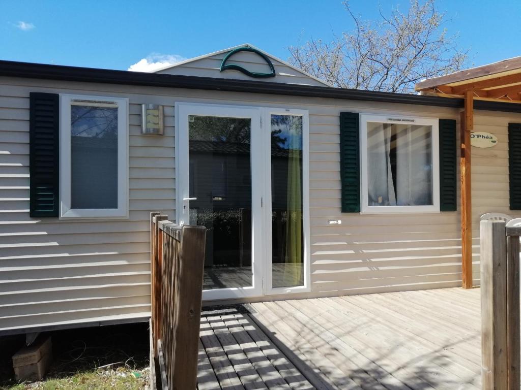 une porte d'entrée d'une maison avec une terrasse couverte dans l'établissement Mobil home Chez 118 Alain, à La Roque-dʼAnthéron