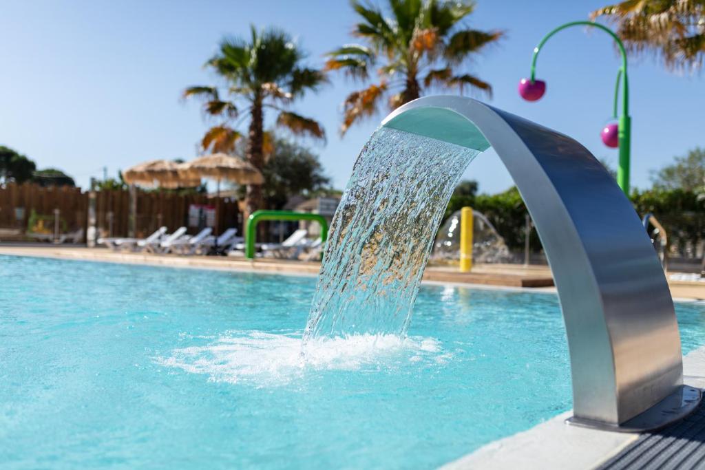 une fontaine à eau dans une piscine dans l'établissement Camping Les Amandiers, à Castelnau-de-Guers
