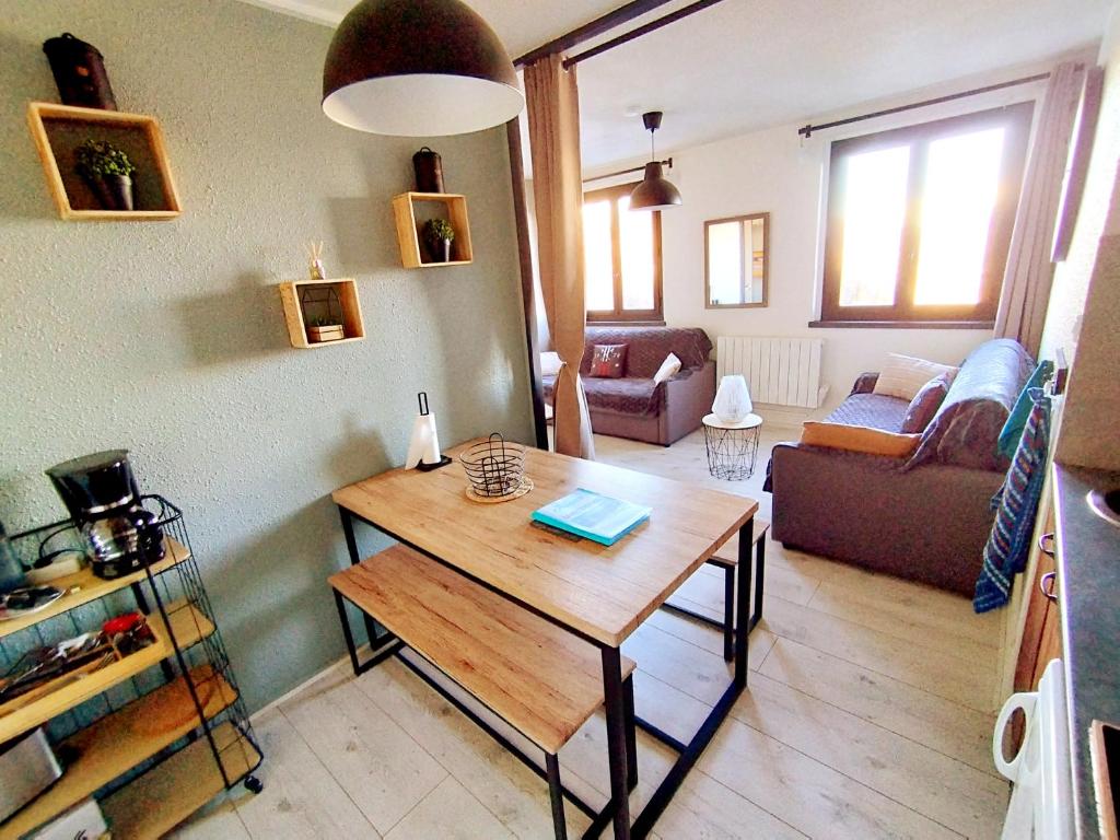 un salon avec une table et un canapé dans l'établissement Coeur de station ESF - Pied de pistes Baïkonour, au Corbier