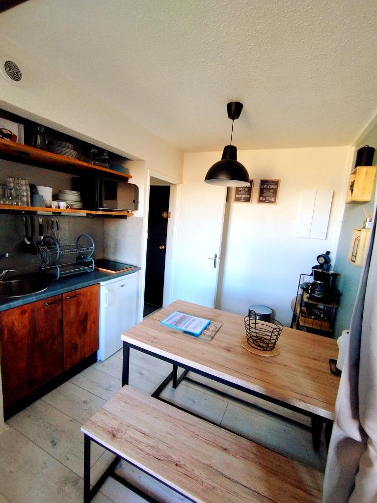 Il comprend une cuisine avec une table en bois et un évier. dans l'établissement Coeur de station ESF - Pied de pistes Baïkonour, au Corbier