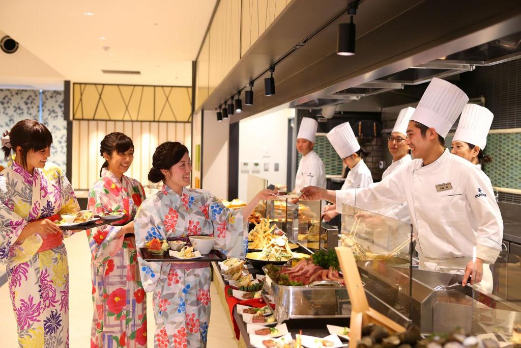 un groupe de personnes debout dans une cuisine préparant la nourriture dans l'établissement Ooedo Onsen Monogatari Beppu Seifu, à Beppu