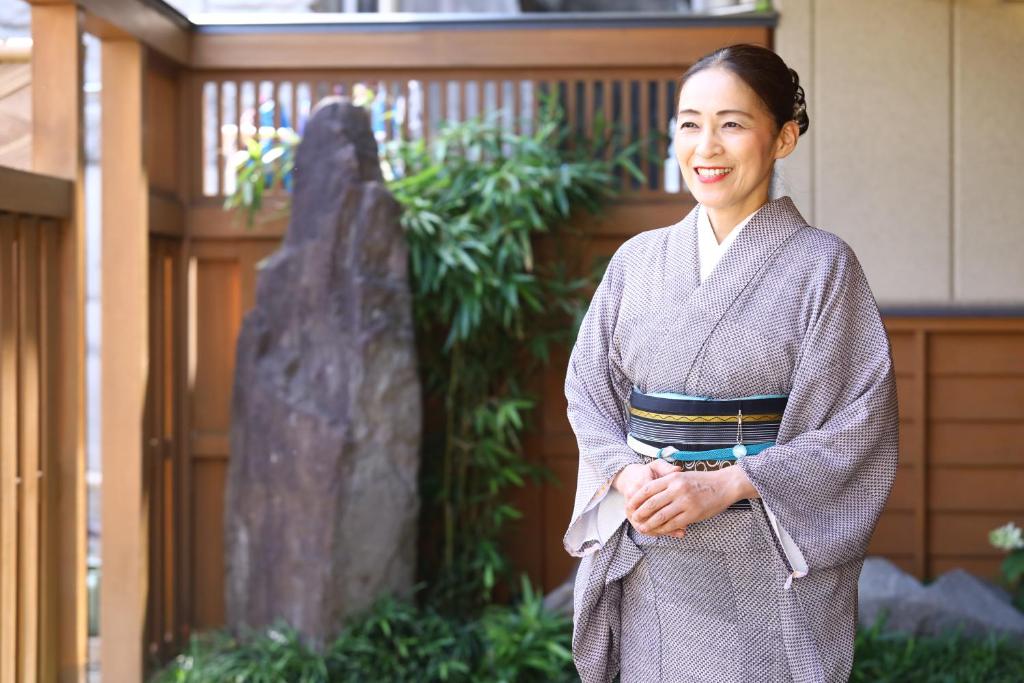 une femme en kimono debout devant un temple dans l'établissement 別所温泉 七草の湯, à Ueda