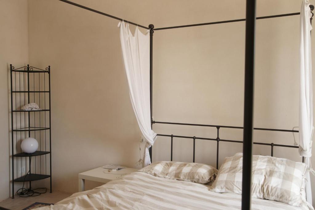 - une chambre avec un lit à baldaquin noir et des draps blancs dans l'établissement trullo contemporaneo, à Serranova