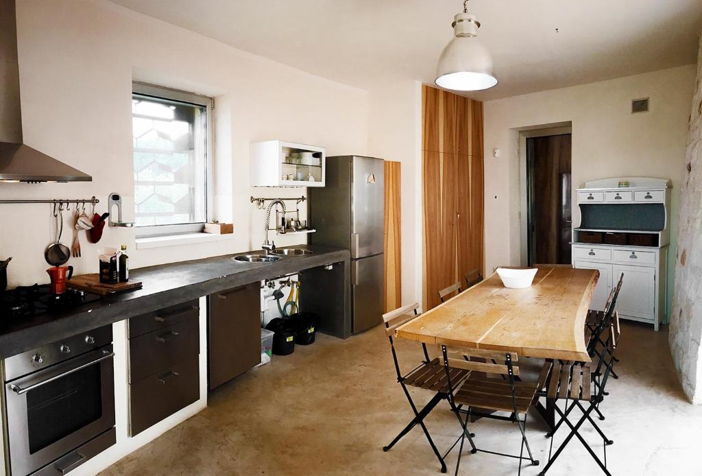 une cuisine avec une table en bois et une salle à manger dans l'établissement trullo contemporaneo, à Serranova