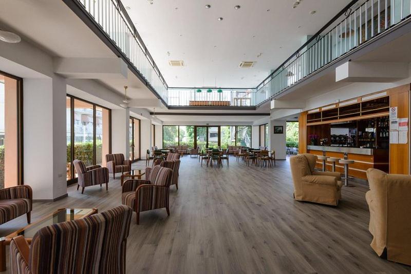 une grande chambre avec des chaises et des tables dans un bâtiment dans l'établissement Diplomat Marine, à Cattolica
