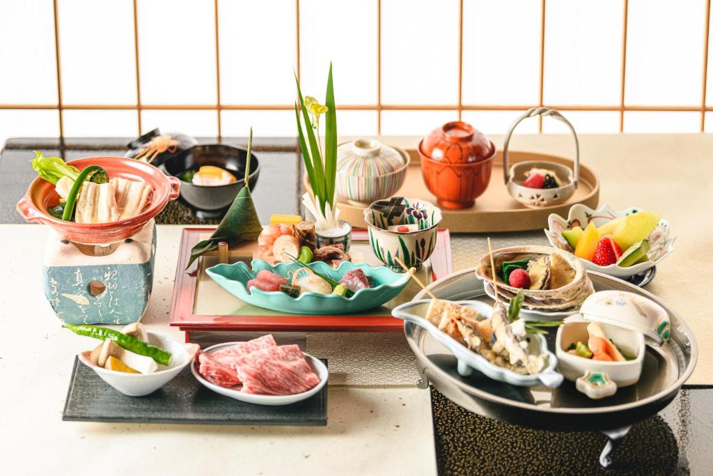 une table remplie de différents types de denrées alimentaires dans des bols dans l'établissement Hotel Wakamizu, à Takarazuka 37 autres photos