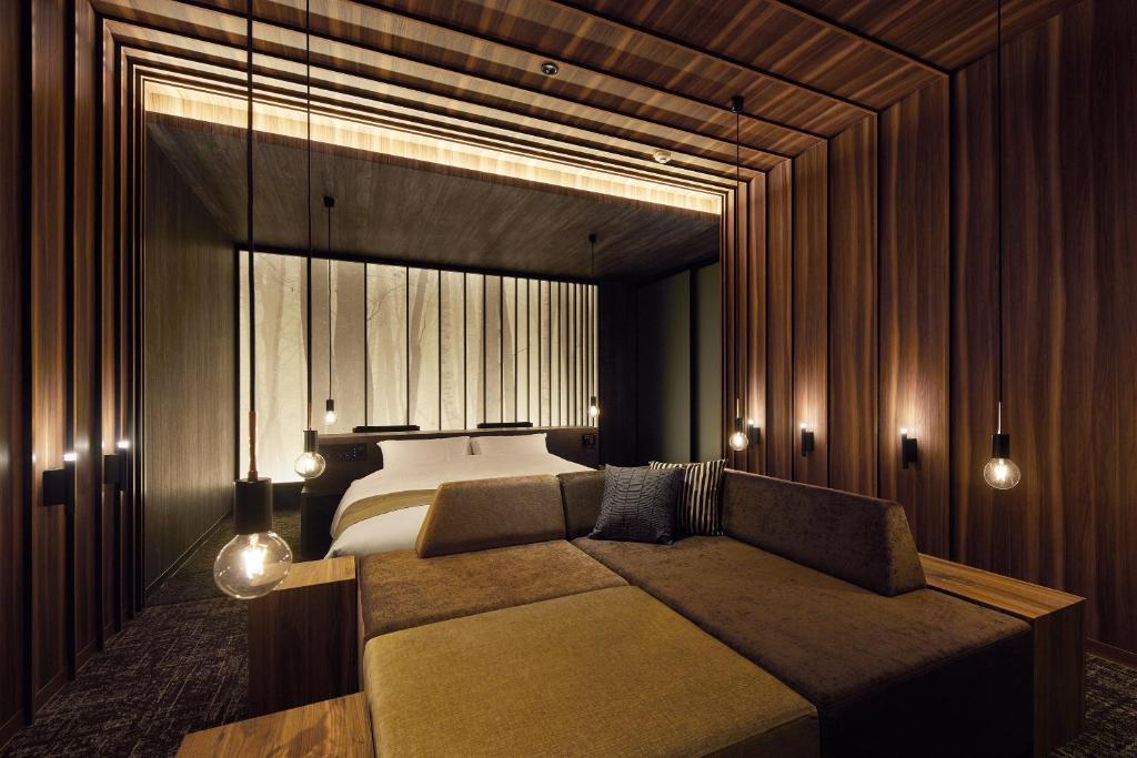 une chambre avec un lit et un canapé dans l'établissement HOTEL FOURSEASONS KITAKAMI Adult only, à Kitakami