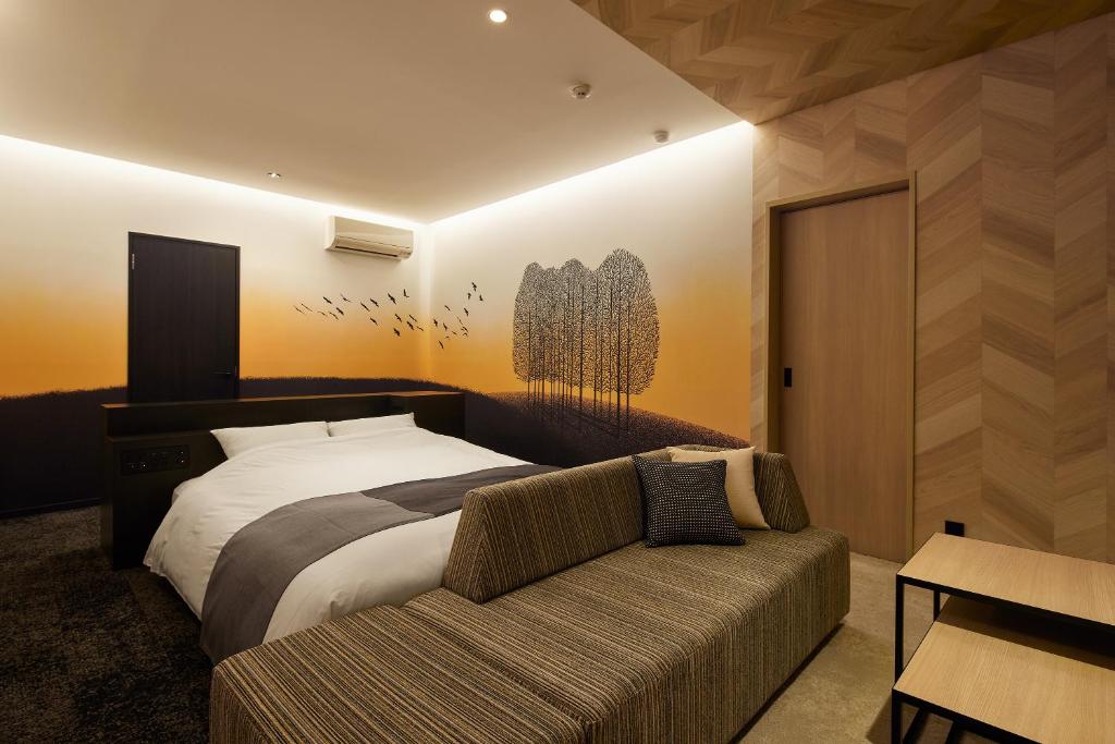 une chambre avec un lit et un canapé dans l'établissement HOTEL FOURSEASONS KITAKAMI Adult only, à Kitakami