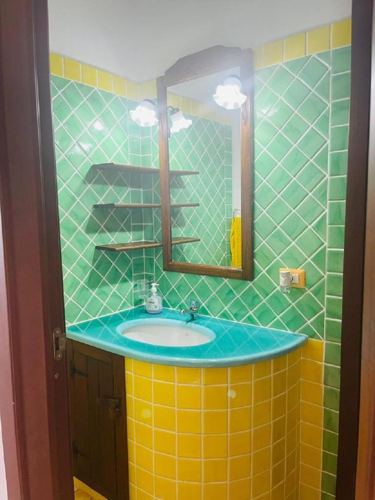 une salle de bain avec un lavabo et un miroir dans l'établissement Eduard Villa, à Stintino 33 autres photos
